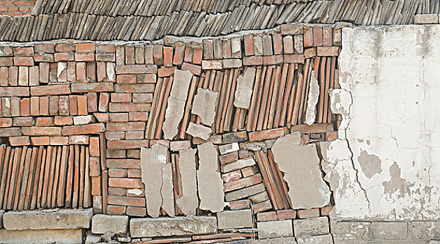 一个用石头,片瓦和砖砌筑的矮墙ashortwallbuiltwithstone,wattandbrick
