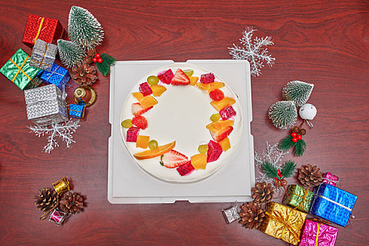 被圣诞装饰品包围的白色水果蛋糕