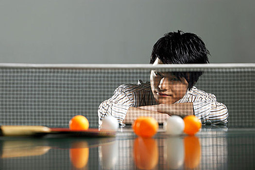 穿着商务衣服趴在乒乓球台上的男人