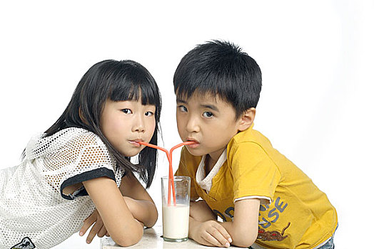 面对面喝着一杯牛奶的小男孩和小女孩