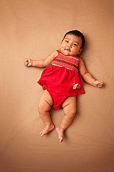 头像,亚洲人,婴儿,躺,穿,红裙,看镜头,微笑,棚拍,褐色背景