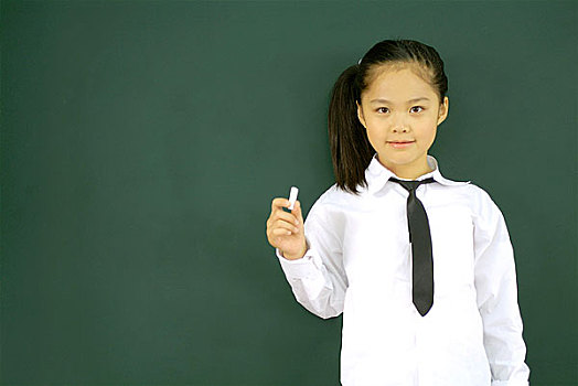教室里背对黑板站着手握粉笔的小女孩