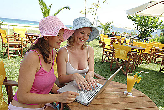 女人,年轻,微笑,太阳帽,笔记本电脑,电子邮件,序列,人,两个,朋友,姐妹,20-30岁,愉悦,高兴,夏天,头饰,帽子,户外,晴朗,酒吧,桌子,坐,度假,休闲,生活方式