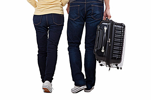 一对青年伴侣拉着行李箱