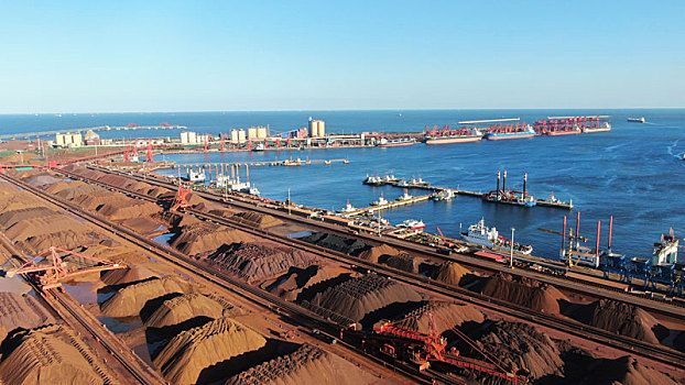 山东省日照市,蓝天下的港口装卸生产现场,货物错落有致生产繁忙有序
