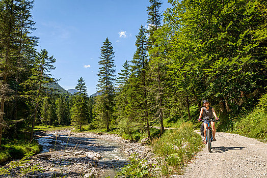 女性,骑车,自行车道,河流,穿过,阿尔卑斯山,自行车,旅游,上巴伐利亚,巴伐利亚,德国,欧洲
