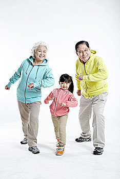 穿运动服的爷爷奶奶和孙女做向前冲的姿势
