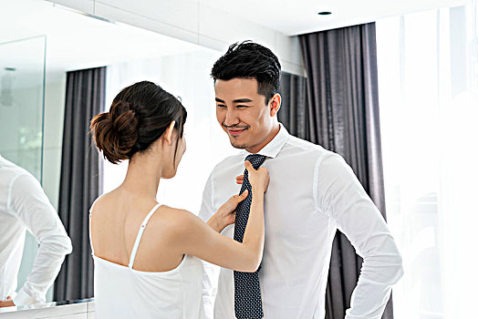 年轻女子帮丈夫调整领带