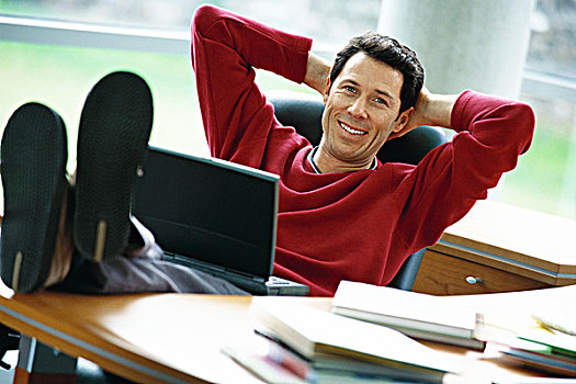 男人,坐,书桌,翘脚,拿着,笔记本电脑,手放头后