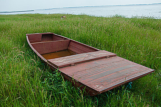 停在湖边草地的小船