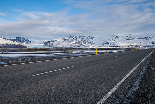 冬季雪地里的高速公路和远方的雪山