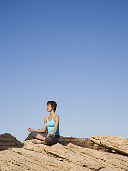 坐,女人,双腿交叉,岩石上,户外,瑜珈