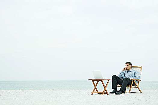 男人,坐,椅子,海滩,看,笔记本电脑,手,下巴