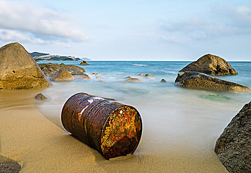 海边沙滩上的汽油桶