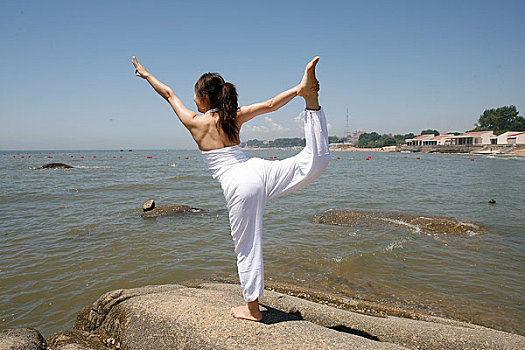 海边练瑜伽的女孩