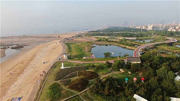 山东省日照市,雨后的海边环境宜人,游客赶海拾贝拍照打卡