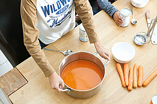 局部,男孩,厨房用桌,拿着,锅,西红柿汤