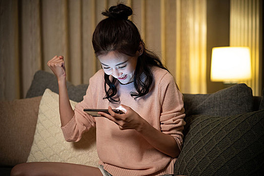 年輕女士在家玩手機游戲
