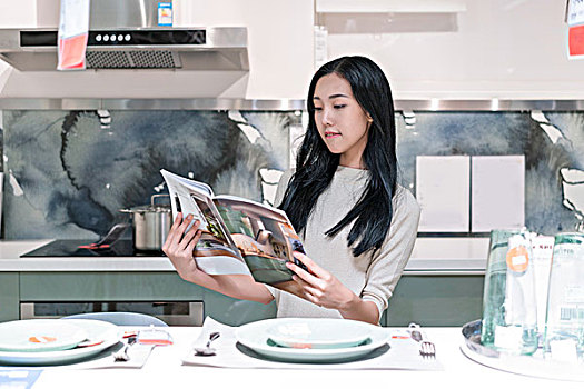 年轻女子在厨房看书