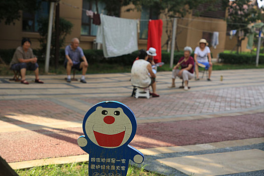 山东省日照市,39度高温天气来袭,小区老年居民树荫下摇扇子纳凉