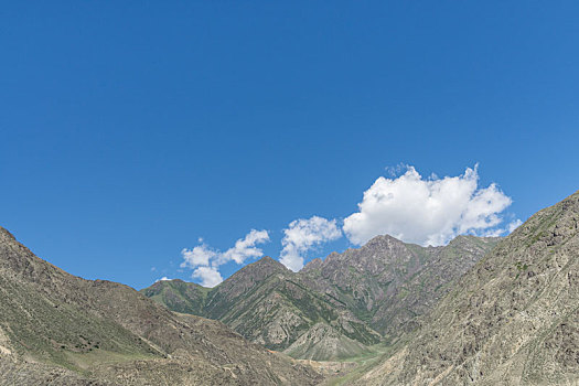 中国新疆夏季蓝天白云下g217独库公路沿途高山戈壁风景