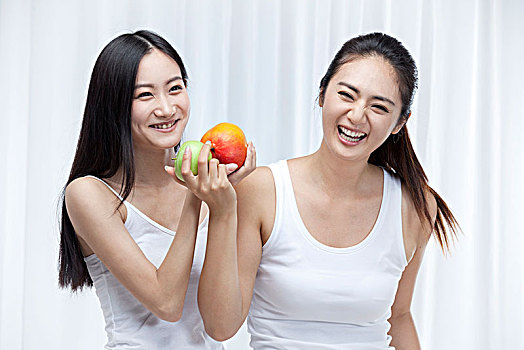 两个拿水果的亚洲女孩