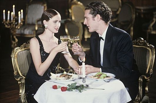 坐,夫妇,餐馆,微笑,黑裙,套装,祝酒,玻璃杯,白葡萄酒,装饰,盘子,正面