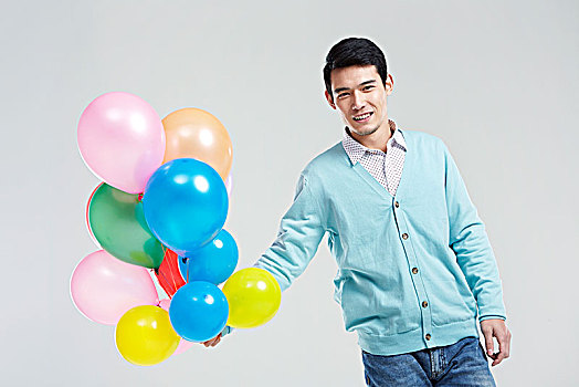 拿彩色气球的亚洲男青年