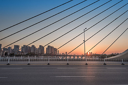 秋季中国抚顺夕阳下的跨河大桥道路