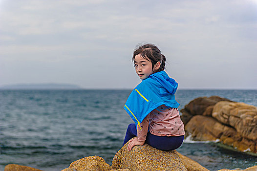 海邊獨坐的小女孩