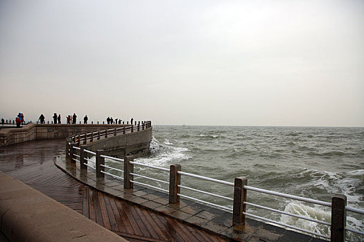 山东省日照市,灯塔风景区风大浪高,游客冒雨观赏浊浪排空奇观