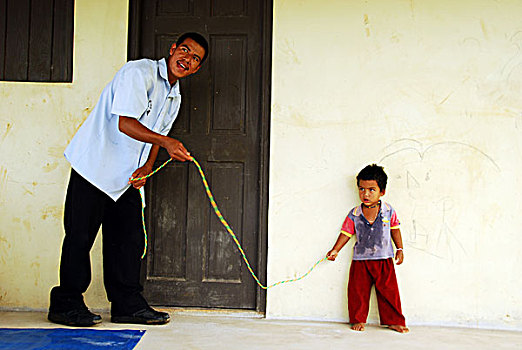 dominica,carib,territory,little,boy,with,colorful,necklace,playing,rope