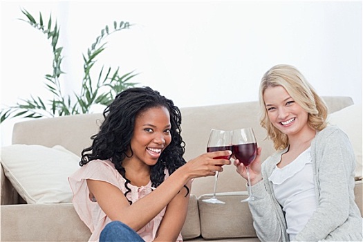 两个女人,坐,地面,拿着,葡萄酒杯