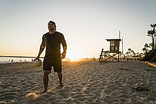 男青年,玩,沙滩排球,日落,新港海滩,加利福尼亚,美国