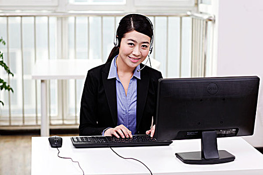 商务女士头戴耳机使用电脑