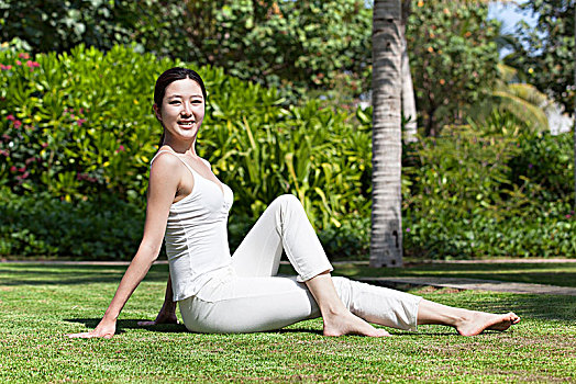 坐在草地上练瑜伽的女士