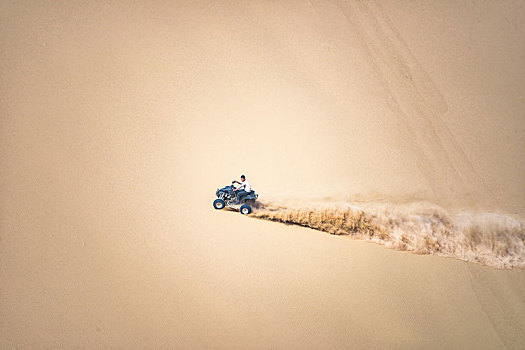 沙漠中骑沙地摩托的人