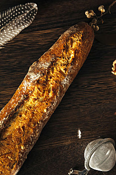 一根新鲜出炉的法国面包法棍摆放在木板上