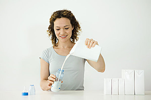 女人,倒牛奶,纸盒,奶瓶,微笑