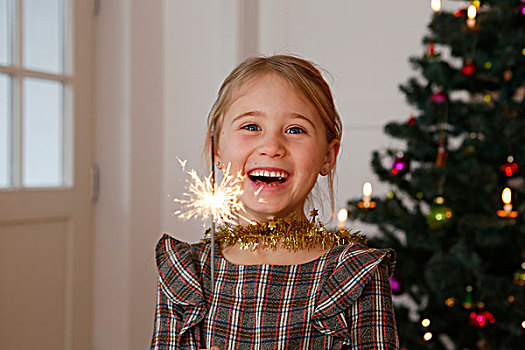 女孩,正面,圣诞树,拿着,闪闪发光,看镜头,微笑