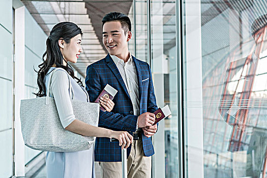 年轻情侣在机场拿着护照和机票