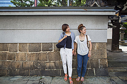 两个女人,站立,室外,墙壁