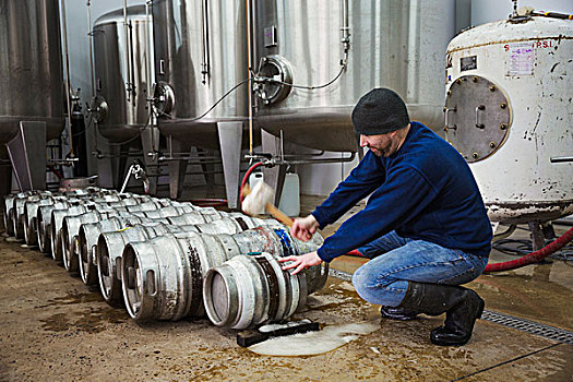 男人,跪着,锤打,金属,啤酒,桶,大,发酵,酒罐