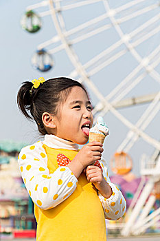 小女孩在游乐园吃冰淇淋