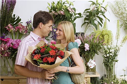 情侣,搂抱,旁侧,展示,花,店,拿着,花束,红花,微笑,侧面视角