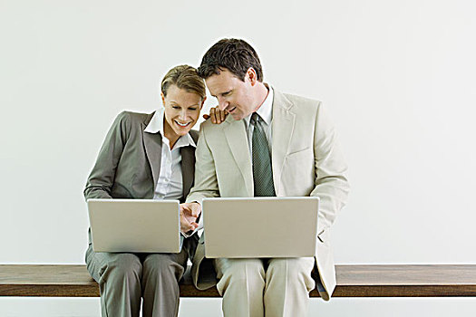 男性,女性,商务合作,坐,并排,使用笔记本,电脑,微笑