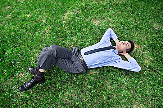 躺在草地上的商務男士