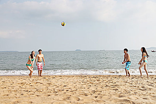 时尚青年人海边沙滩排球