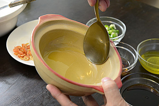 煲仔饭制作过程之一,锅底淋抹上一层油,以便饭不粘锅,广东