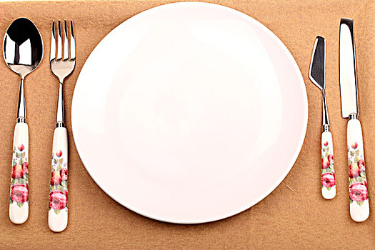 摆放在桌布上的一套西餐银色餐具